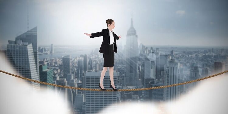 akenvrouw balanceert op een touw, met de skyline van New York City op de achtergrond