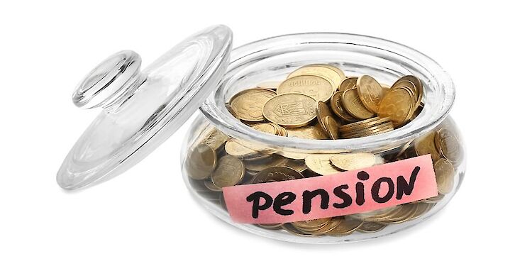 Een laag glazen potje met muntgeld erin met deksel ernaast. Op het potje staat 'pension'.