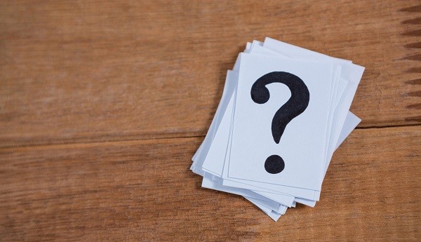 stapel papiertjes, op bovensta staat een zwarte vraagteken
