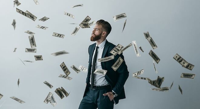 Man die staat met briefgeld wat vliegt om hem heen