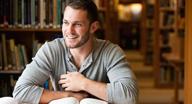 Jongen in bibliotheek die kijkt naar buiten
