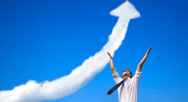 zakenman die omhoog kijkt met handne in lucht waar een stijgende pijl van contrail in de lucht te zien is