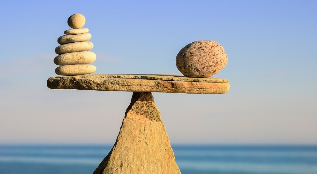 Stenen die balanceren op een driehoekige steen. Met de zee op de achtergrond
