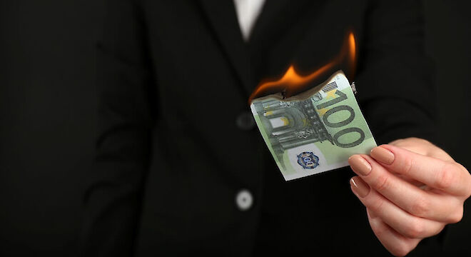 Vrouwenhand met 100 eurobiljet die in brand staat