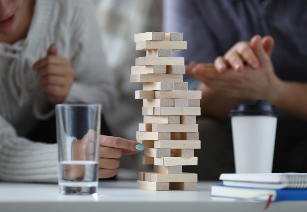 Jenga toren met twee mensen die spelen.