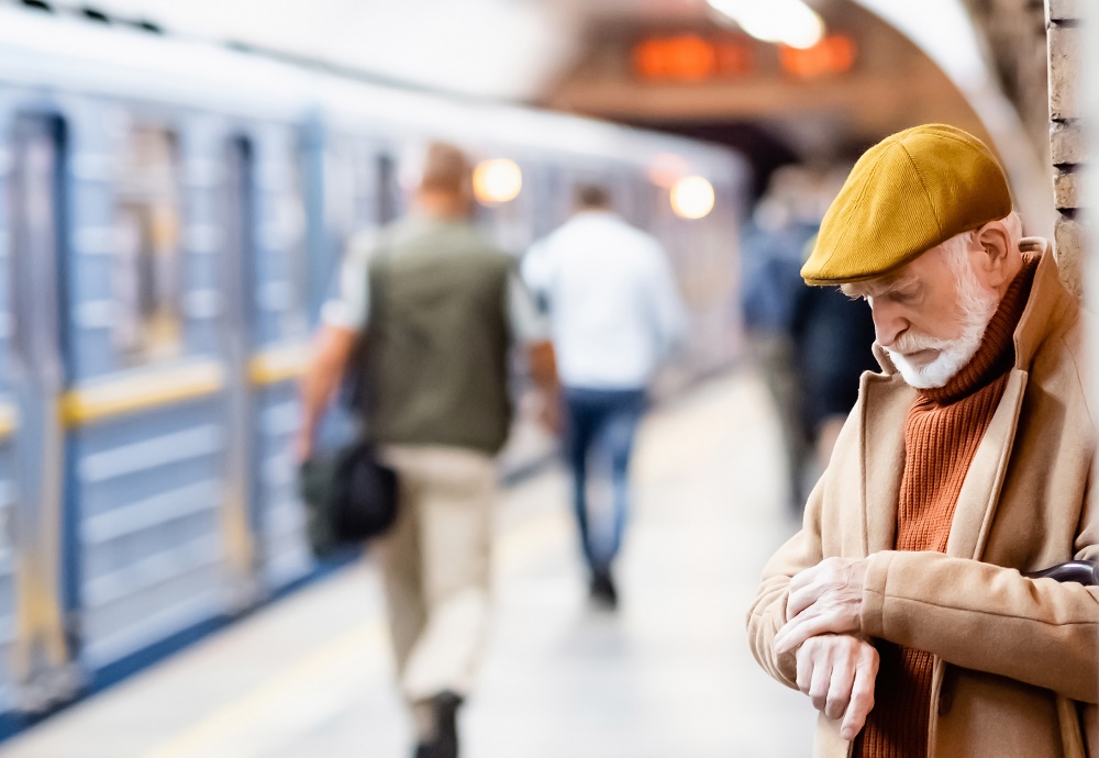Reiziger wacht bij trein en kijkt op horloge