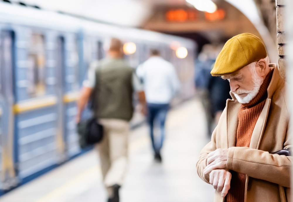 Man wacht bij trein en kijk op horloge.