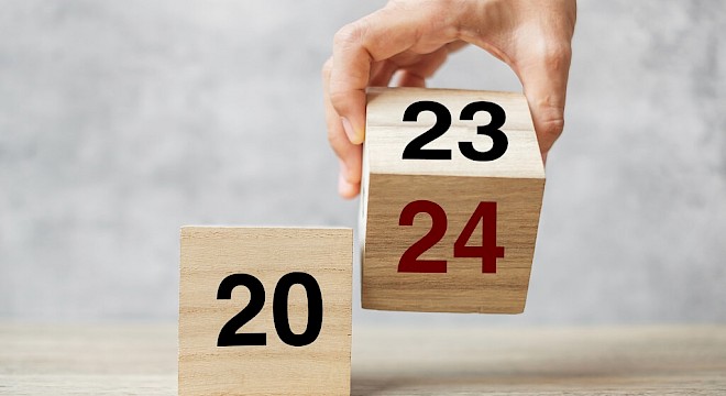 twee houten blokjes. een met 20 erop en een met 23 die wordt omgedraaid naar andere kant met 24 erop
