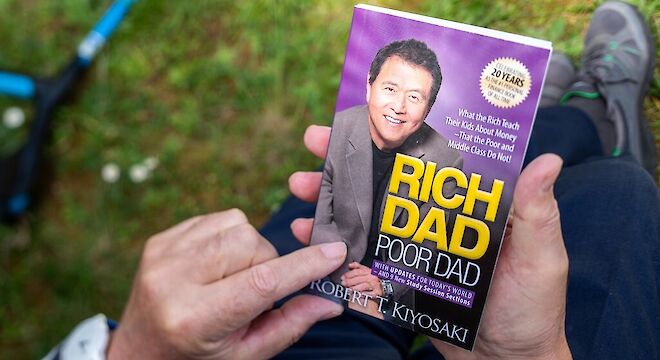 Boek rich dad poor dad in hand van man