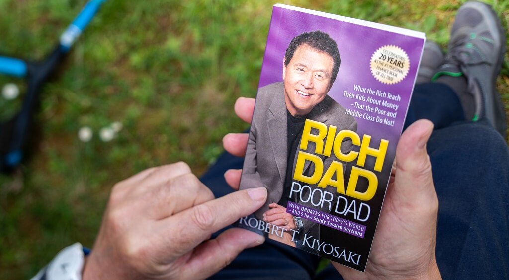 Boek rich dad poor dad in hand van man